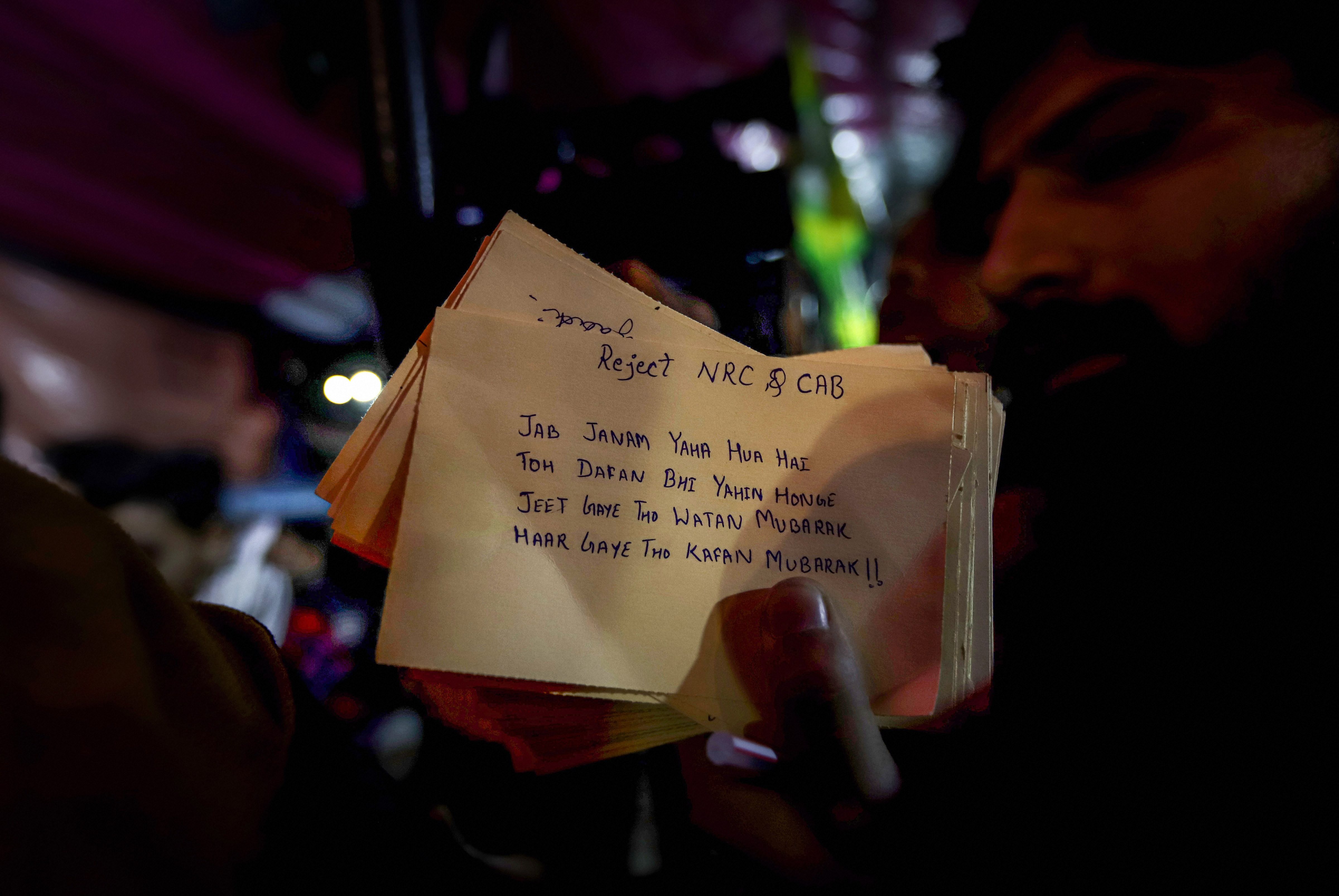 A protester shows postcards addressed to Prime Minister Narendra Modi at Shaheen Bagh in New Delhi on Saturday