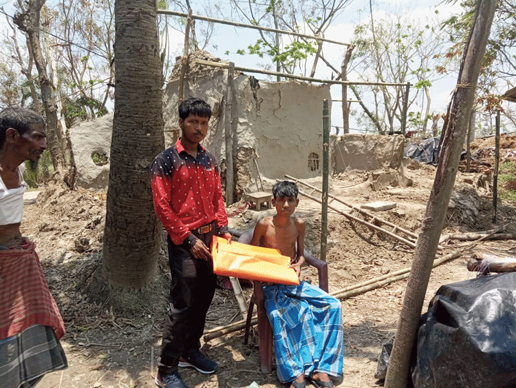Ajizul Halder (centre) distributes relief material in the Sunderbans