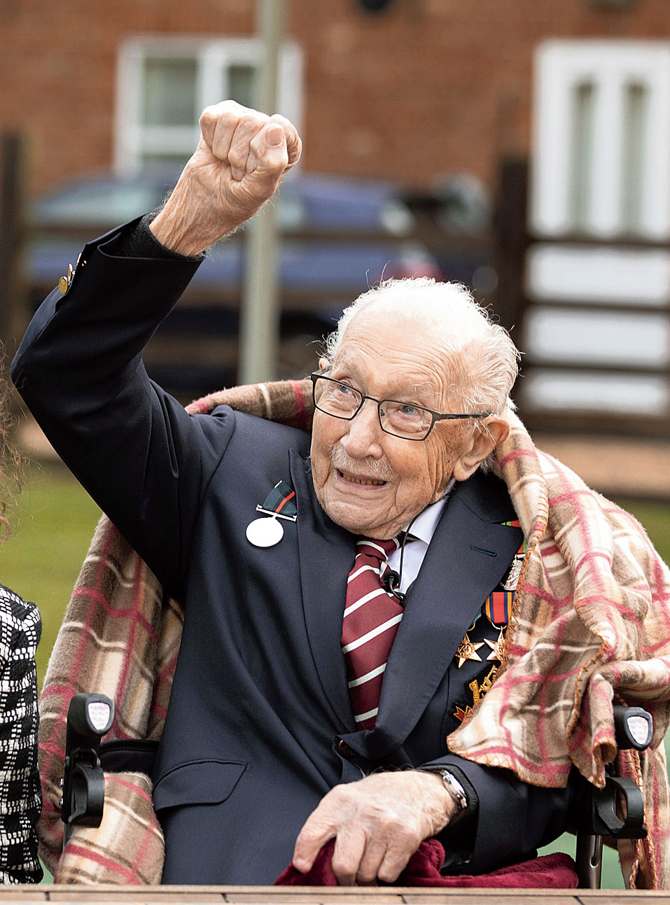 A picture released by Capture the Light Photography shows war veteran Captain Tom Moore raising his fist to the Battle of Britain Memorial flypast of a Spitfire and a Hurricane over his home in Marston Moretaine, Britain.
