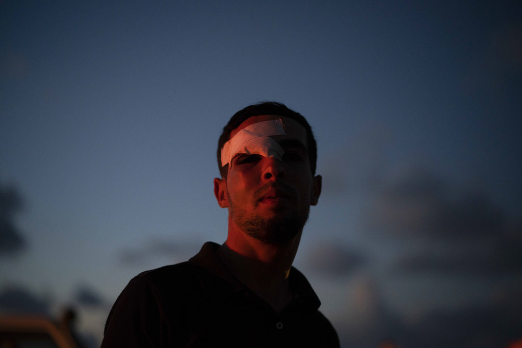 A Palestinian who was injured during a protest stands near the border. "Every Friday we wait for the injuries, and every Friday it's always the same," says a doctor. "They always come."