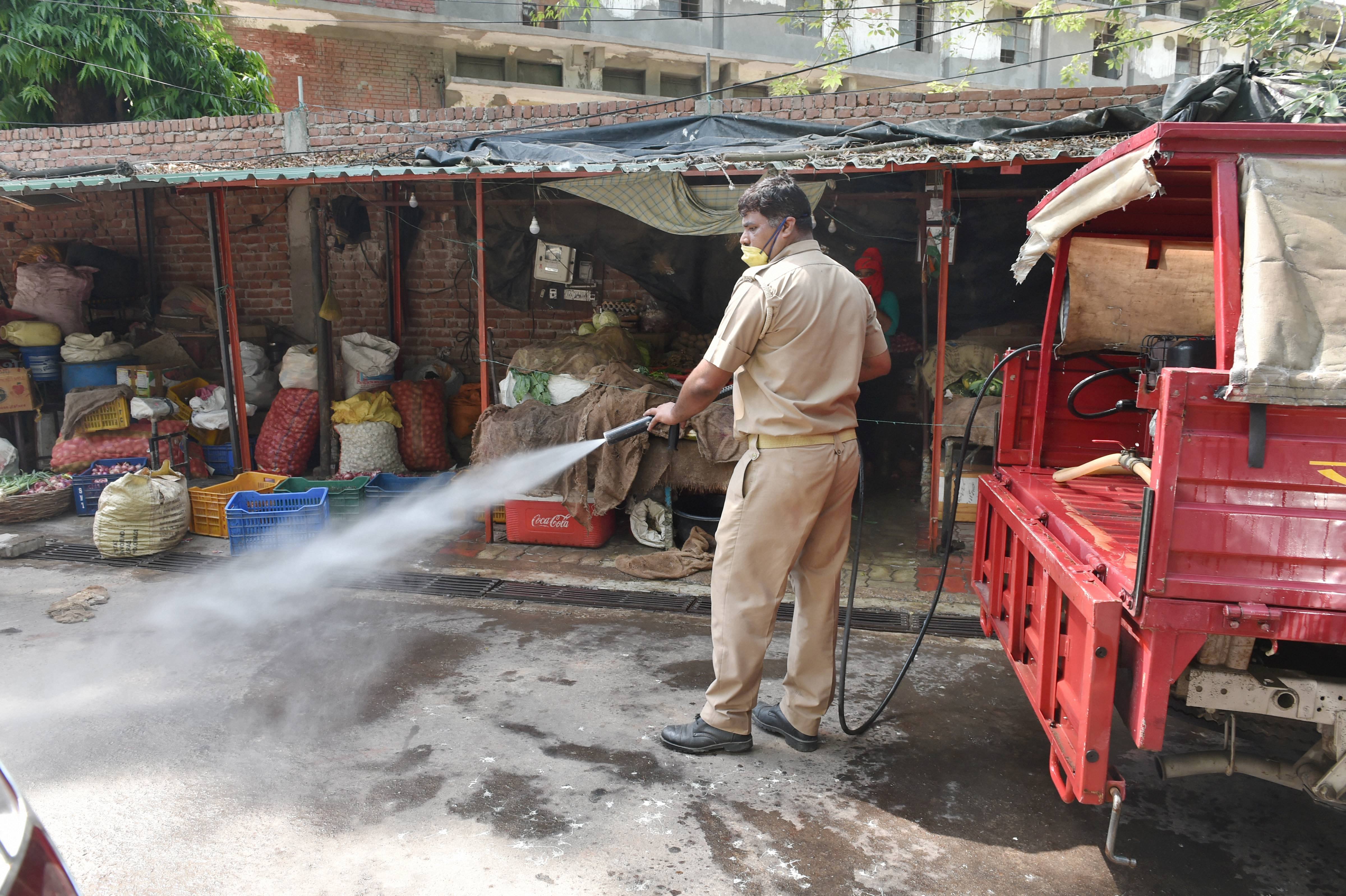 UP fire and emergency services employee sprays disinfectant in the Narahi area of Hazratganj, as a measure to contain the spread of coronavirus, during the nationwide lockdown, in Lucknow, Friday, May 15, 2020