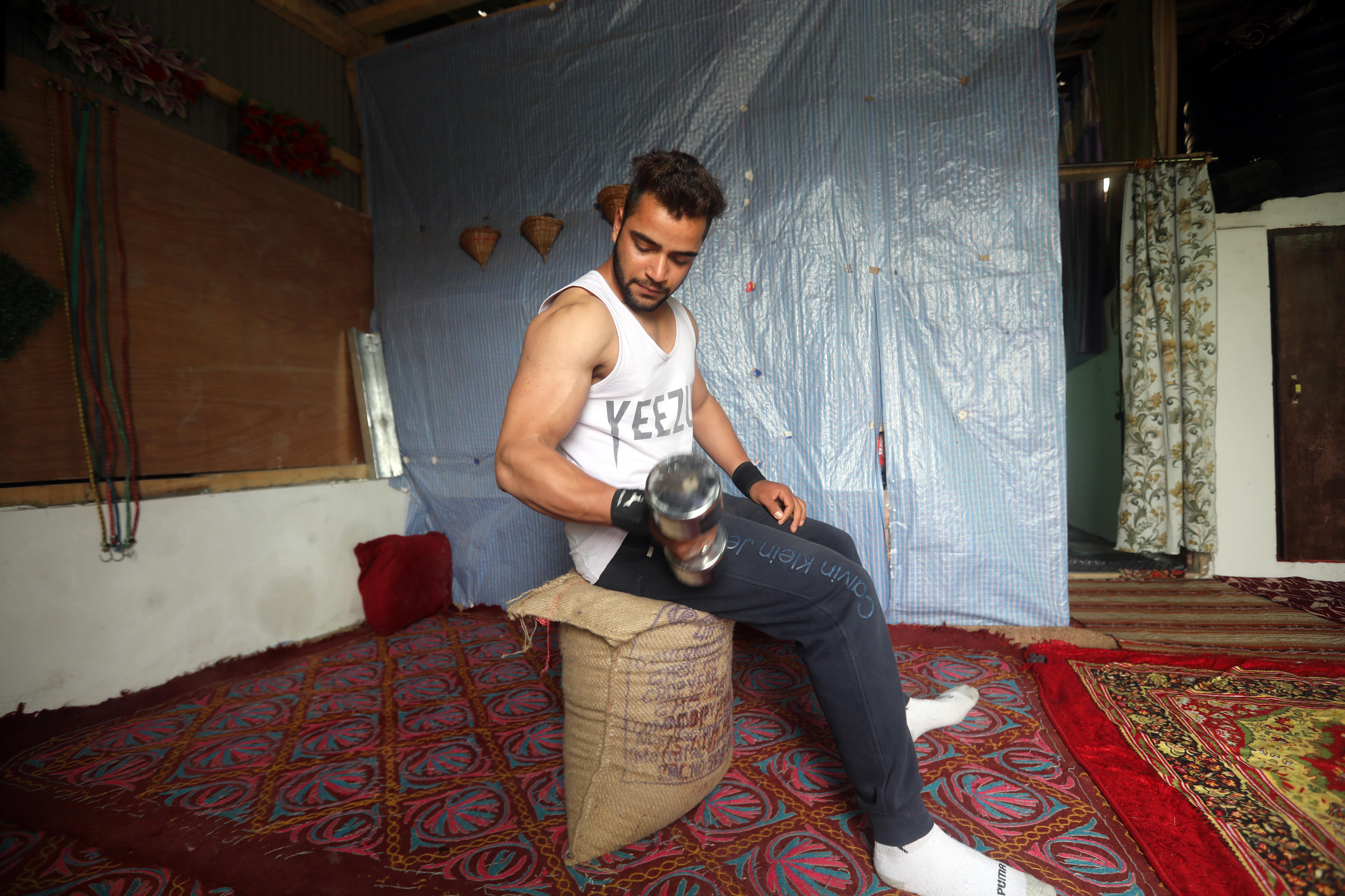 GOOD HEALTH: A young man exercises in a room he has converted into a gym at his home in Battamaloo, Srinagar.