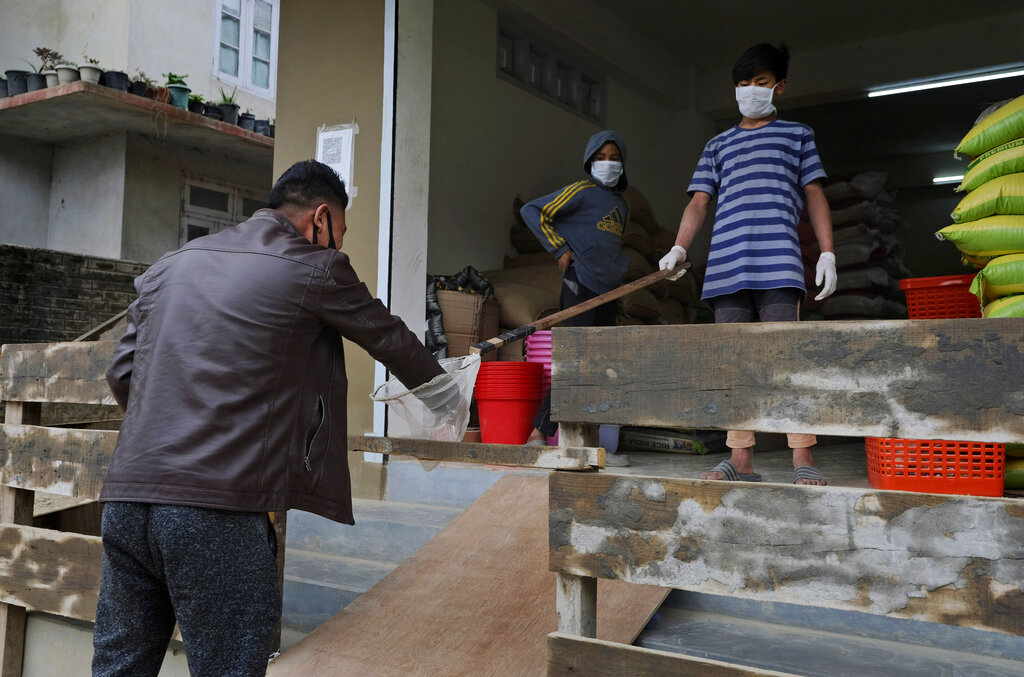 A man receives change from a shop, handed over in a basket in observance of social distancing norms, during lockdown to curb the spread of the coronavirus in Kohima, Nagaland, Wednesday, May 13, 2020.