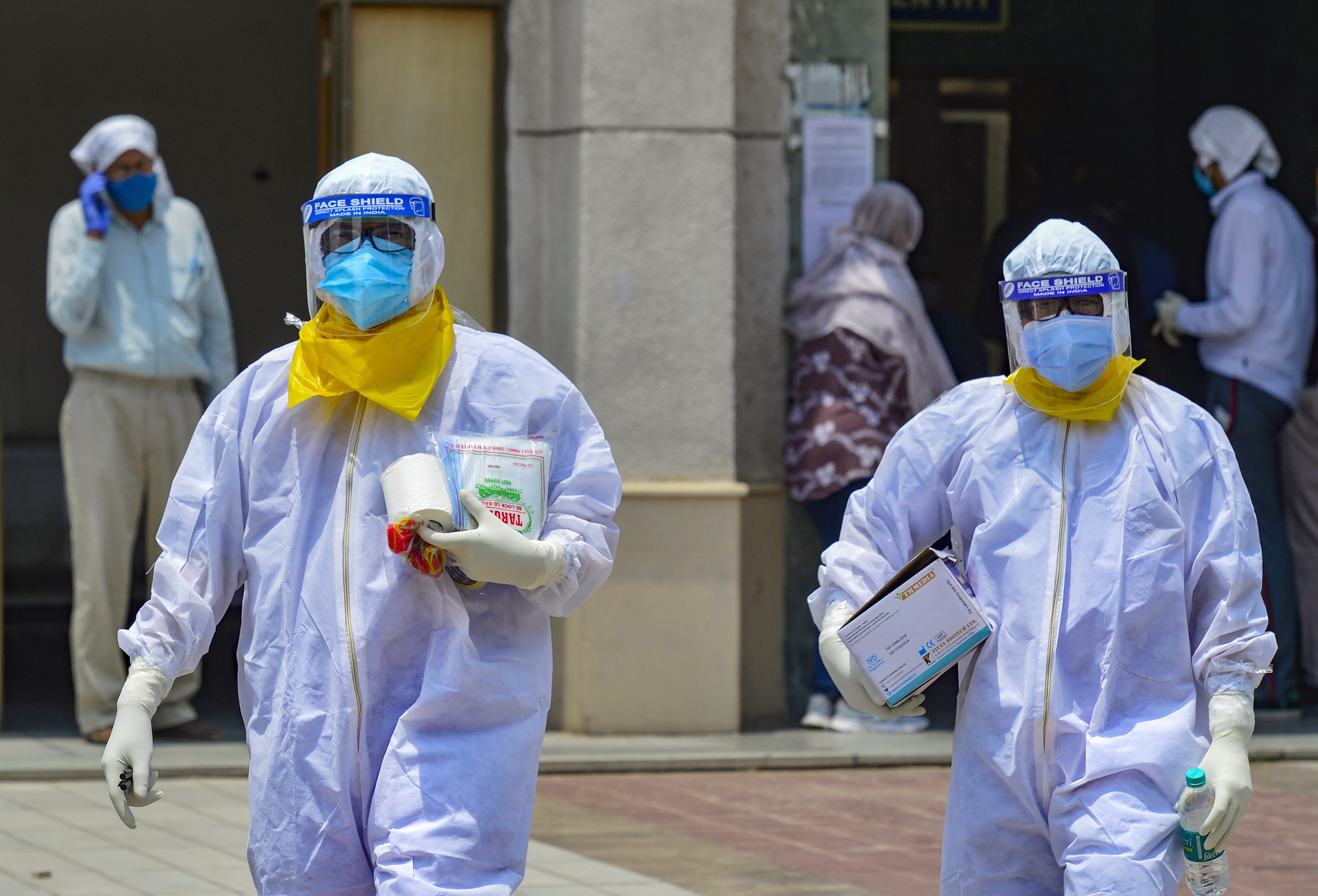 Medics take samples of suspected Covid-19 patients for lab test at a government hospital in New Delhi on Tuesday.