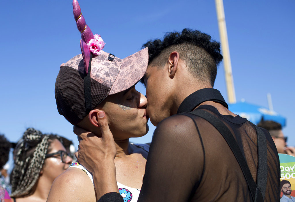 A couple steals a kiss kisses during the pride parade.