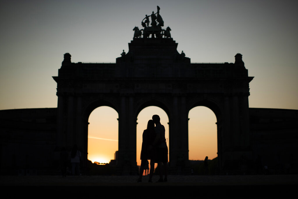 A couple hugs next to the triumphal arch at the Cinquantenaire Park during a partial lockdown to prevent the spread of Covid-19 in Brussels, Saturday, April 11, 2020.