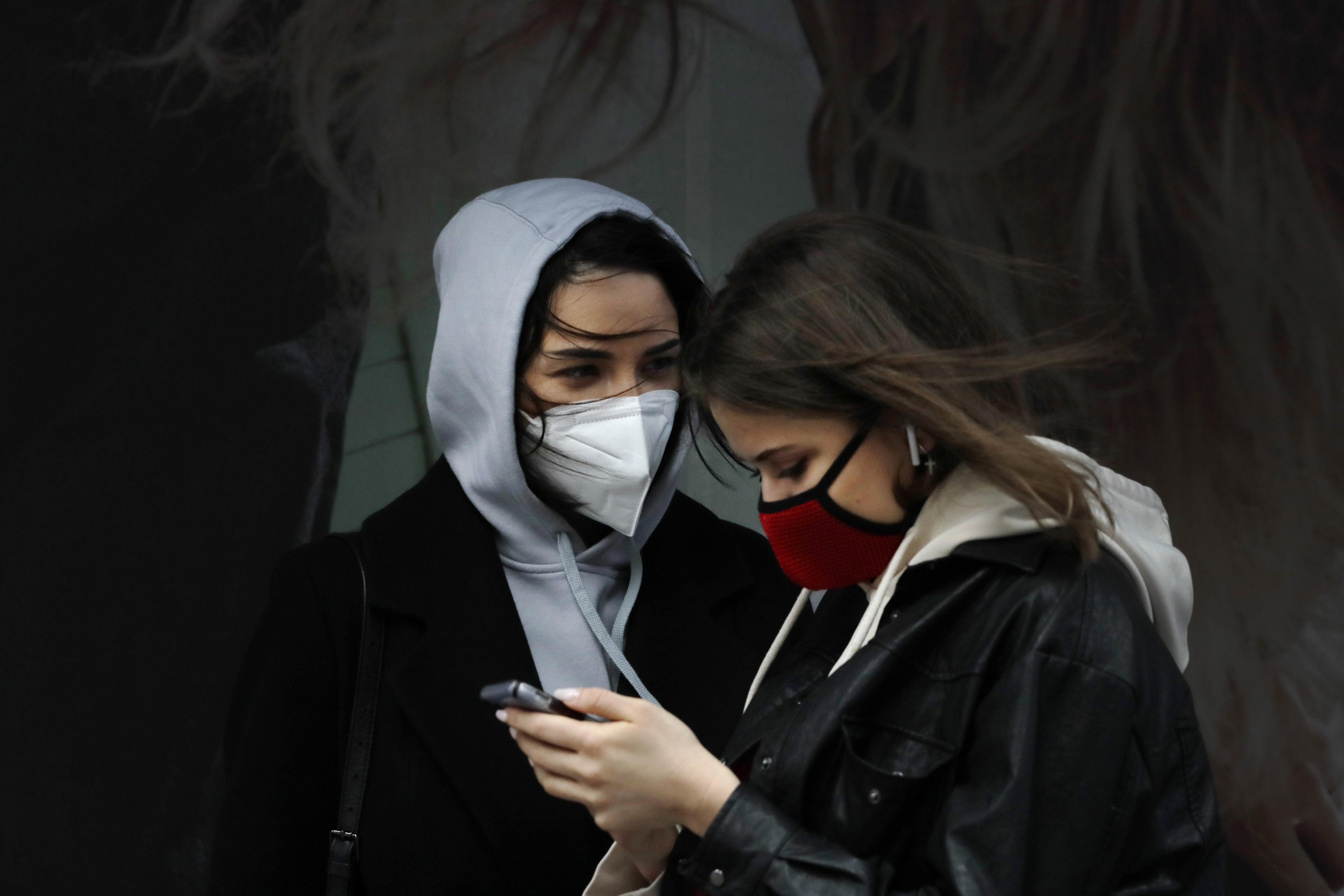 Women wearing masks talk in New York's Times Square