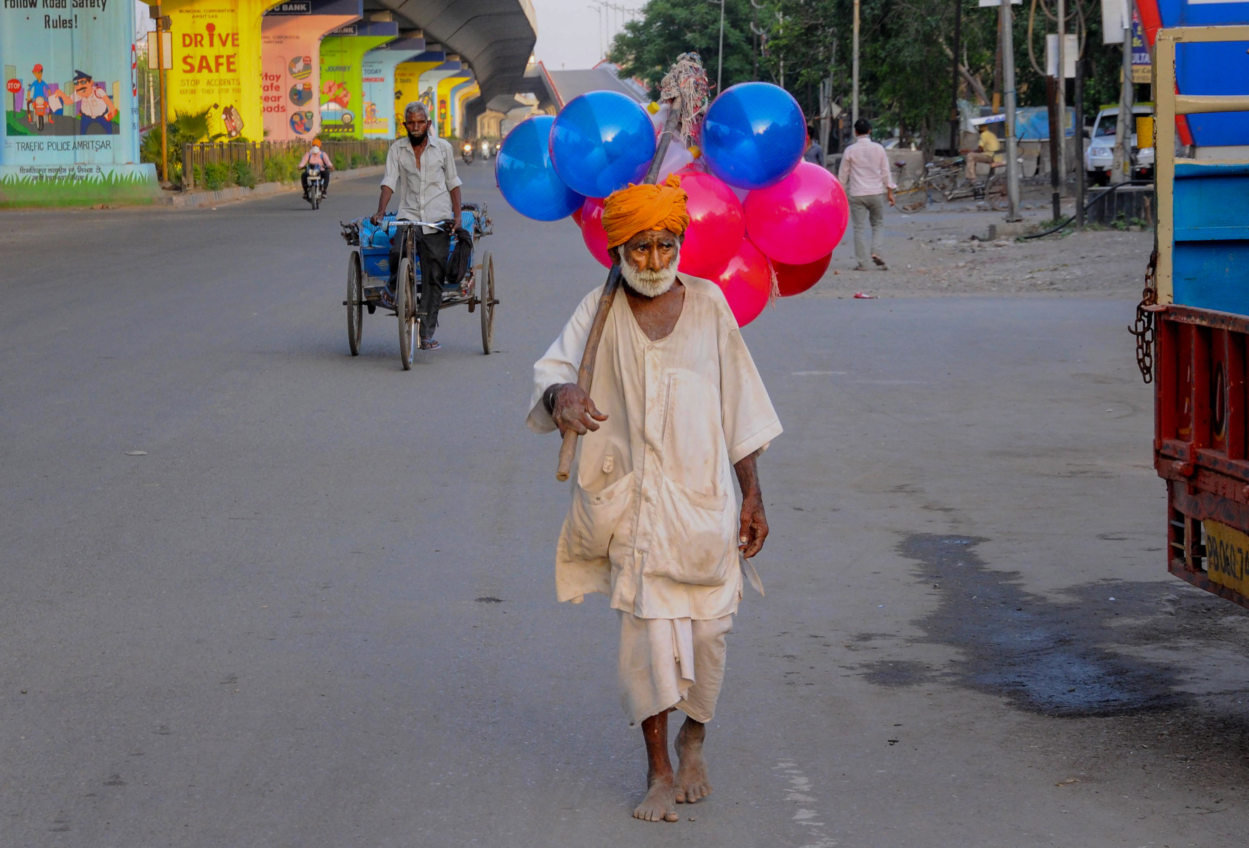An elderly man sells toy balls during ongoing Covid-19 lockdown, on the outskirts of Amritsar, Thursday, April 30, 2020.