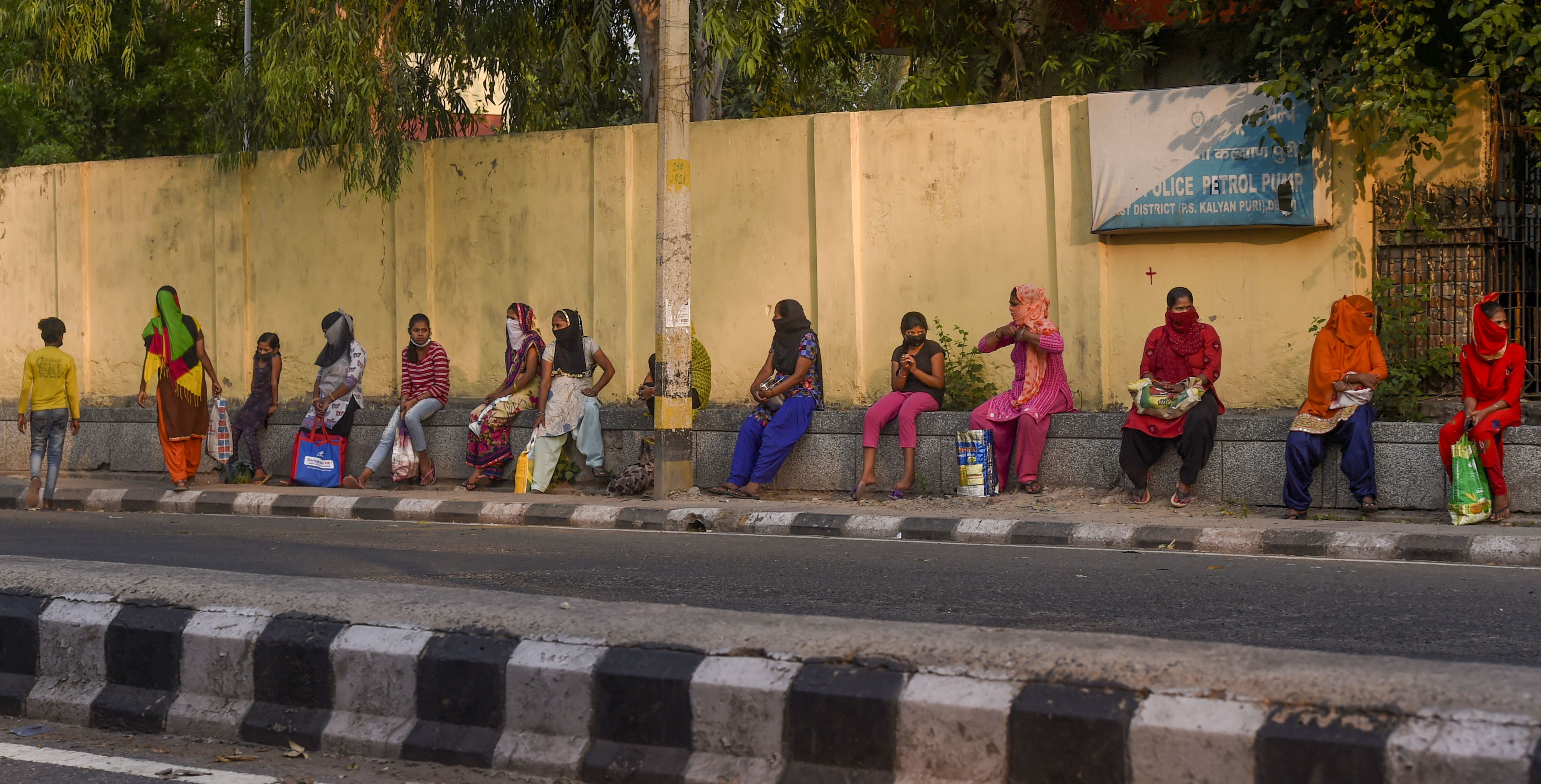People wait in a queue to collect food items distributed by volunteers at Trilokpuri during the nationwide lockdown, imposed in wake of the coronavirus pandemic, in New Delhi, Monday, April 27, 2020