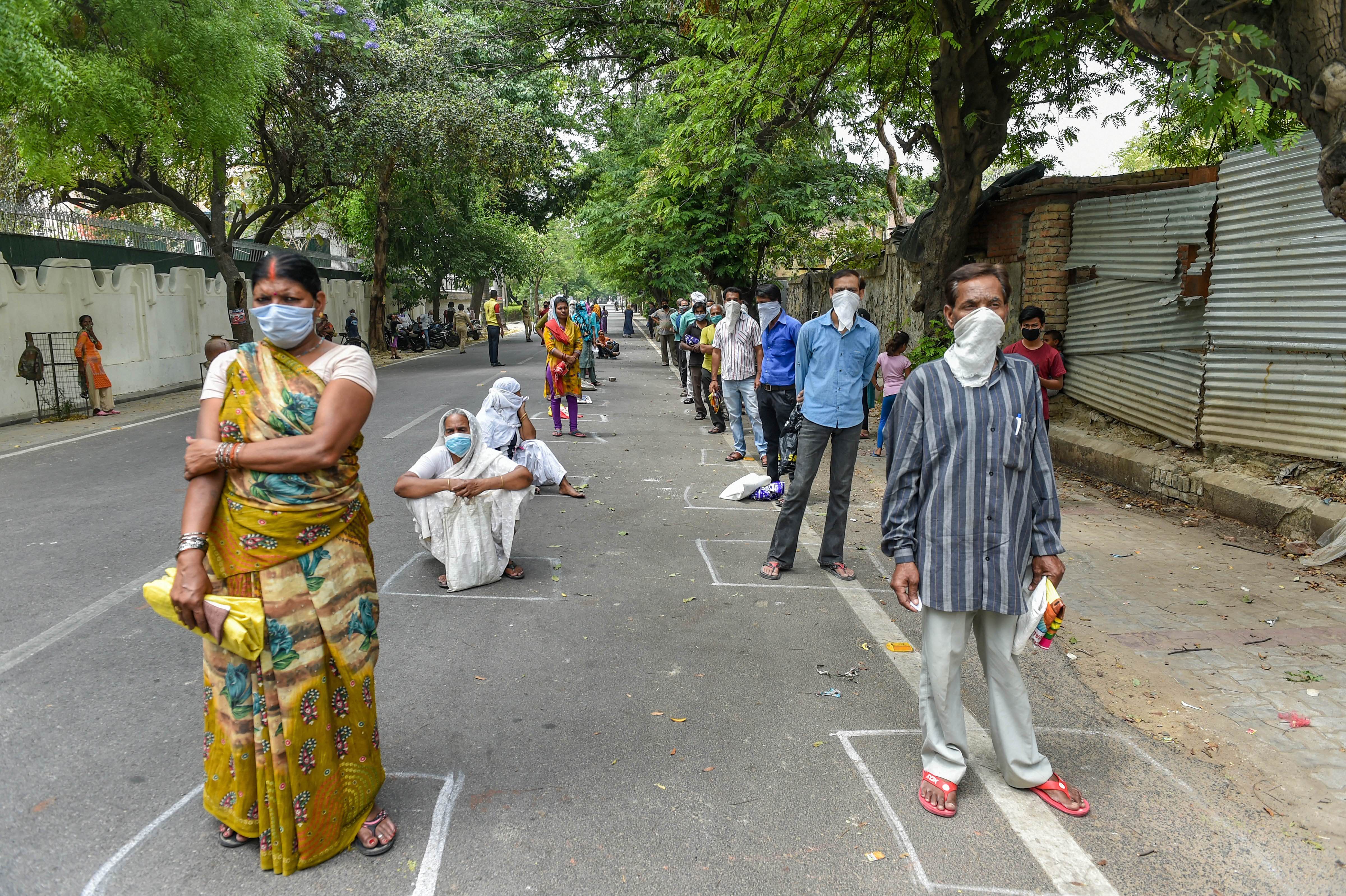 People follow social-distancing guidelines, waiting in queues outside a government store, to collect free ration under Pradhan Mantri Gareeb Kalyan Anna Yojna, during ongoing Covid-19 lockdown, in Lucknow, Wednesday, April 15, 2020