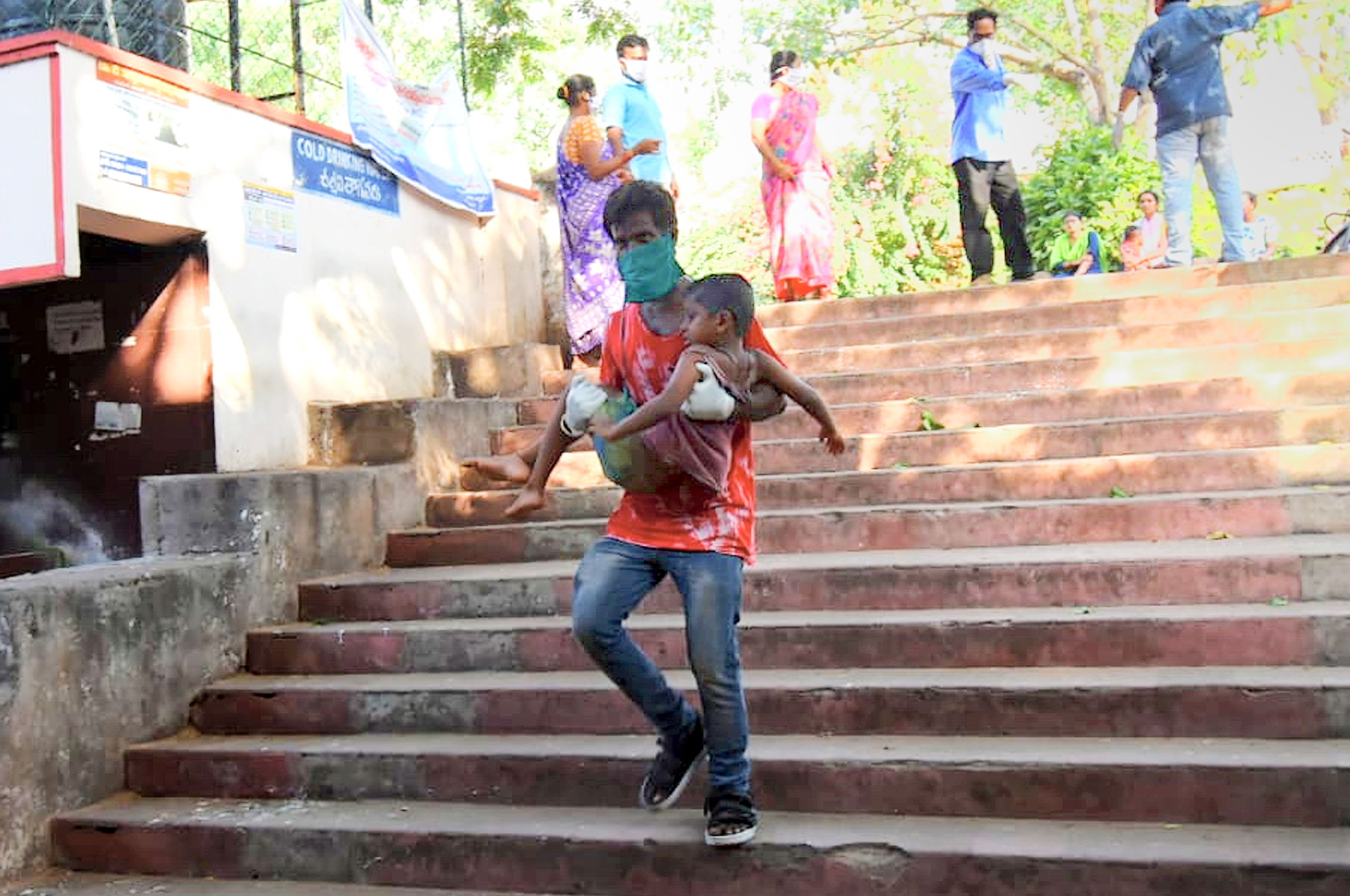 A father rushes his child to the King George Hospital for treatment after a major chemical gas leakage at LG Polymers industry in R.R. Venkatapuram village, Visakhapatnam, Thursday, May 07, 2020