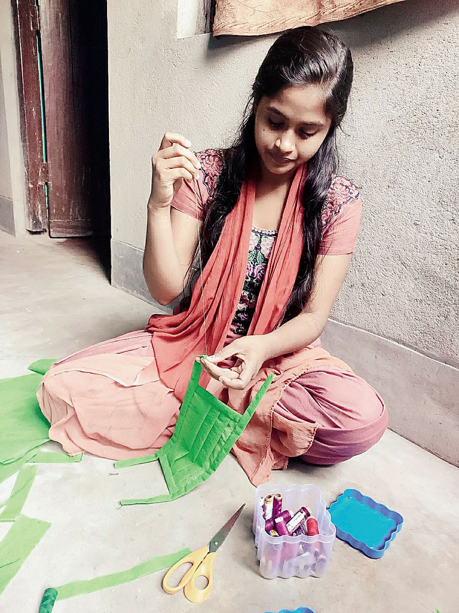 A student of Mahila College, Chaibasa, makes masks at her residence. 