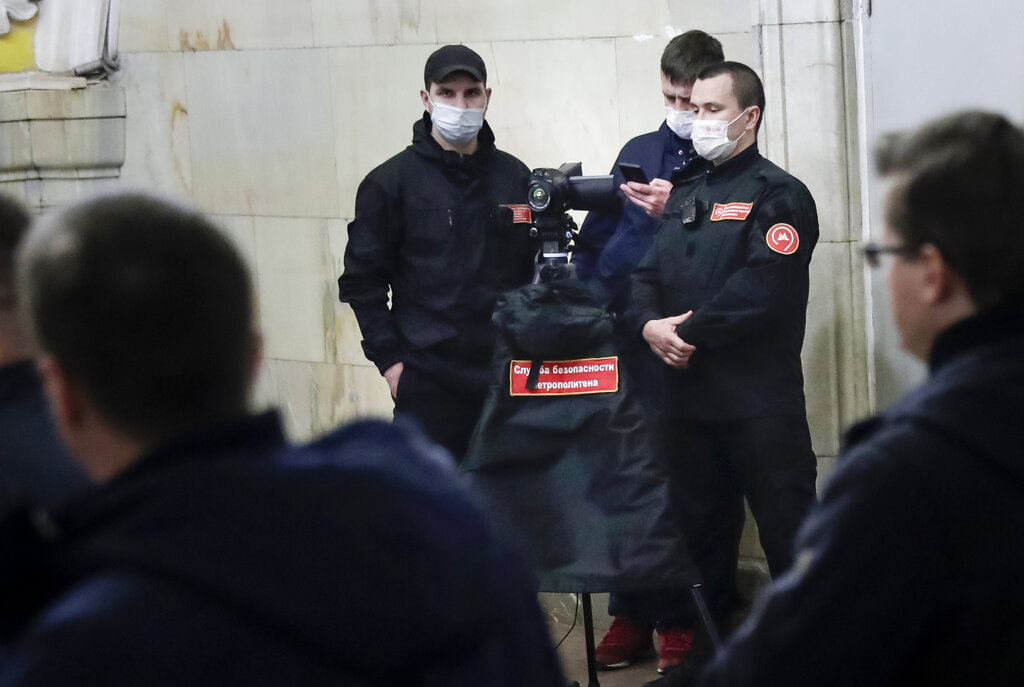 Subway security service team prepare to use a thermal scanner to check the temperature of passengers inside the Komsomolskaya Metro (subway) station in Moscow, Russia, Wednesday, March 18, 2020.