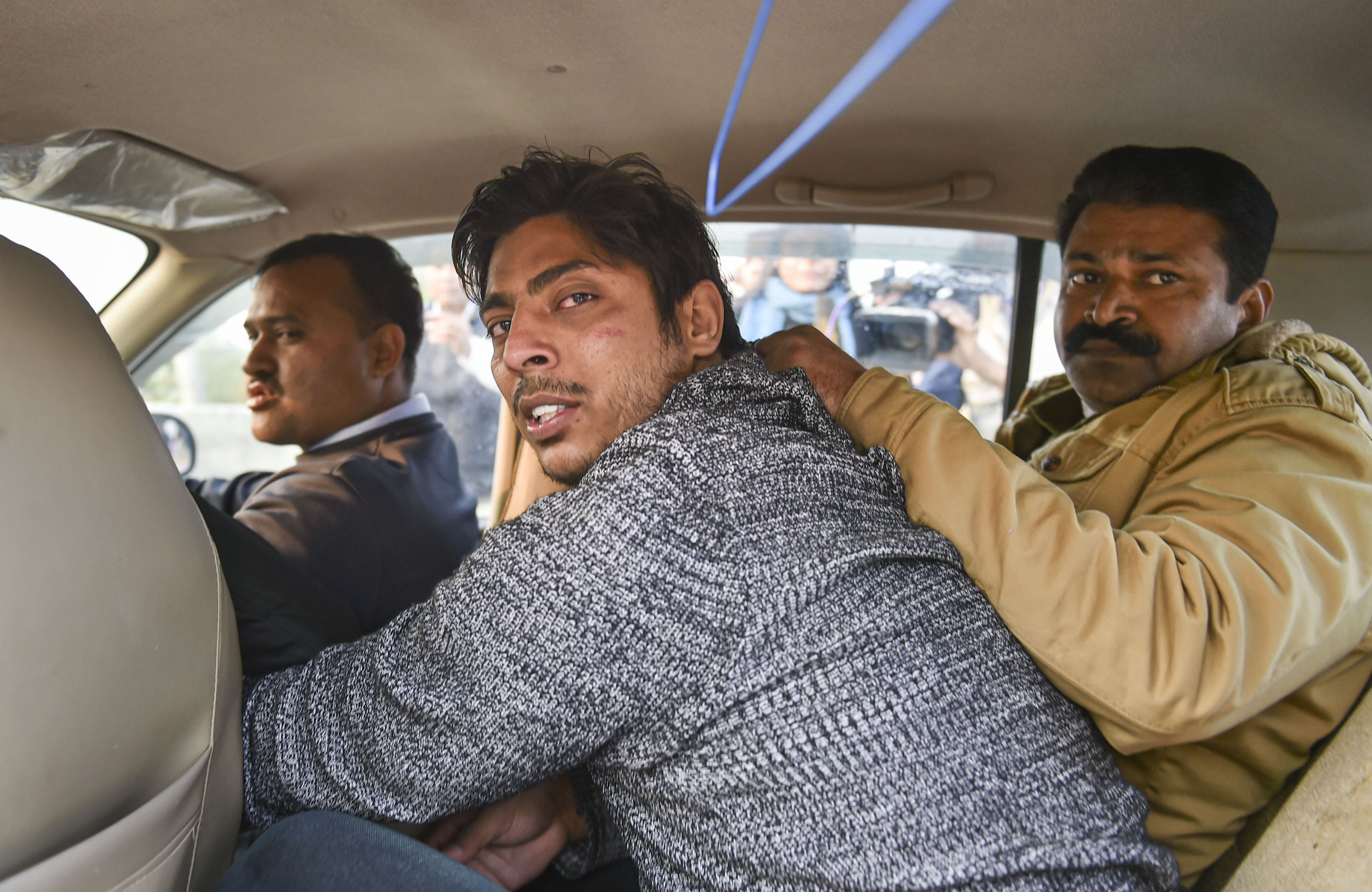 Police take away Kapil Gujjar after he allegedly opened fire in the Shaheen Bagh area of New Delhi, Saturday, February 1, 2020