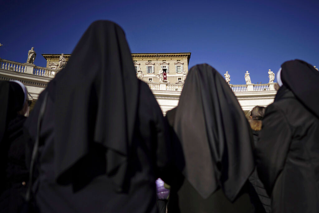 Nuns watch Pope Francis as he delivers his blessings during the Angelus noon prayer at the Vatican on Thursday.