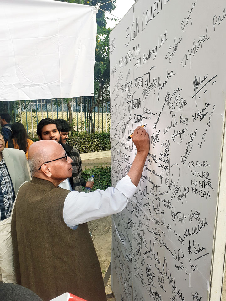 Prashanta Ray, a professor emeritus in sociology and an alumnus signs the wall