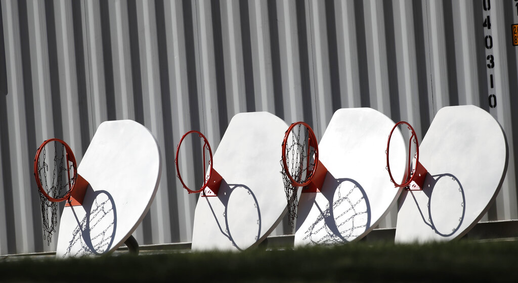 Basketball hoops and backboards, removed from city parks, sit in a row outside a storage facility as a statewide stay-at-home order remains in effect in an effort to reduce the spread of the virus, on Monday, in Wheat Ridge, Colorado, United States