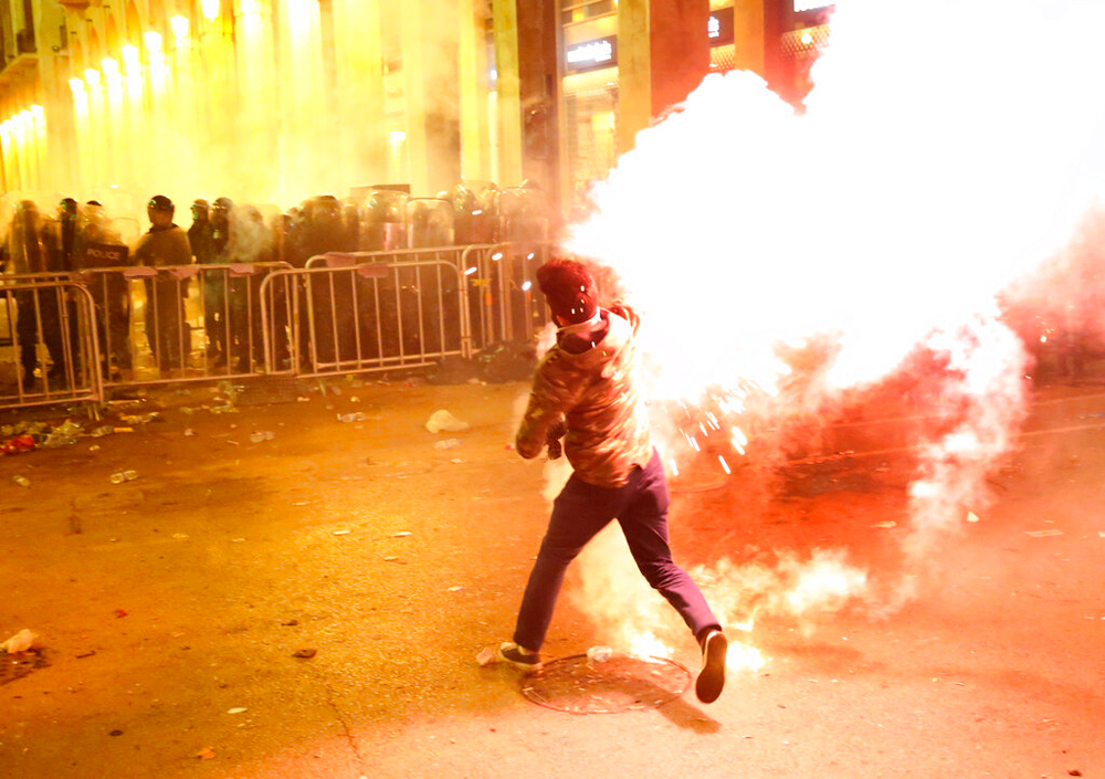 An anti-government protester throws flares against riot police in Beirut, Lebanon, on December 15