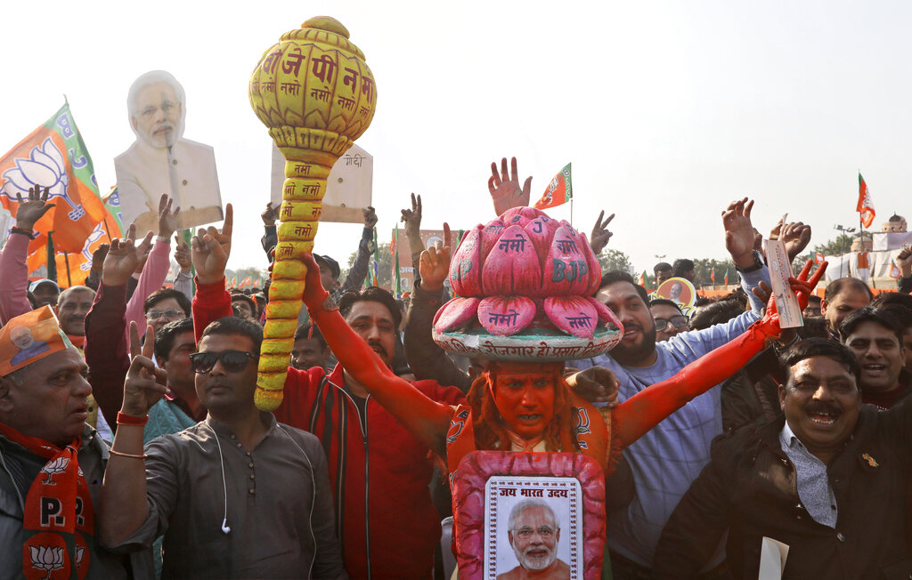 In this Monday, February 3, 2020, photo, a supporter of the ruling Bharatiya Janata Party (BJP) holds a mace, used as a weapon by Hindu god Hanuman, as he shouts slogans during an election campaign rally for the upcoming Delhi elections in New Delhi