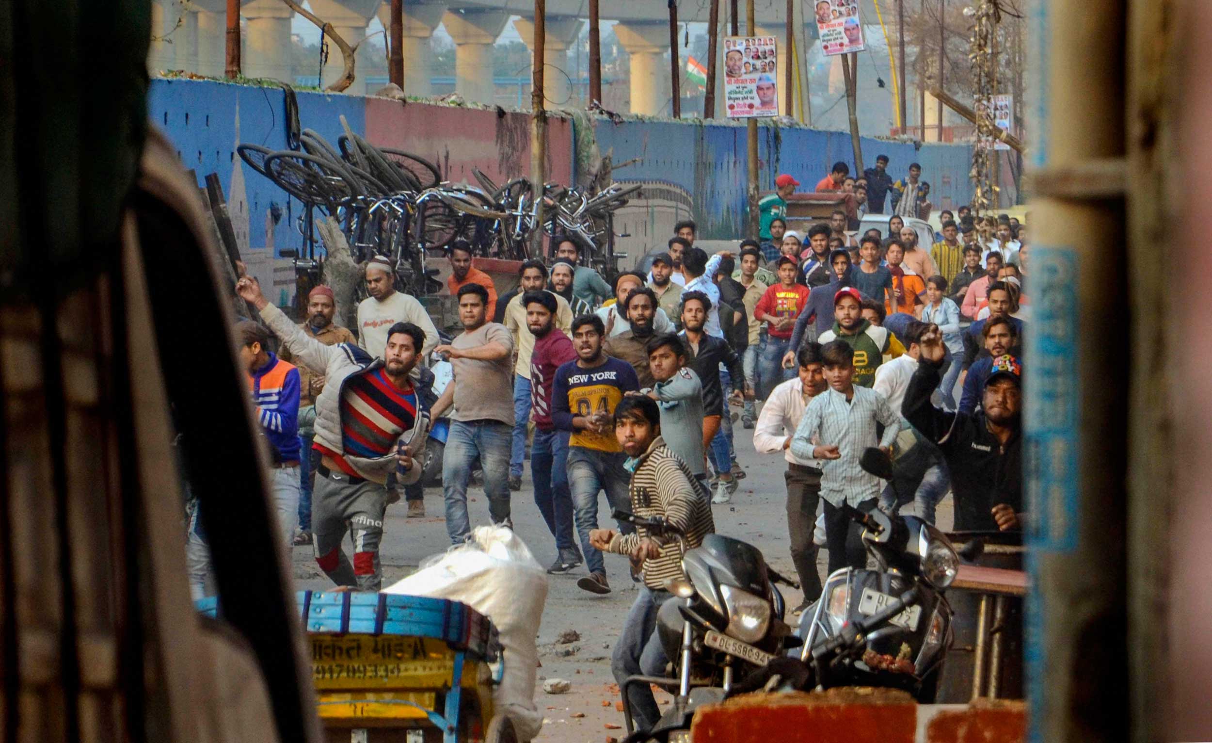 Protesters hurl stones after clashes broke out between pro and anti-CAA groups at Maujpur area, in East Delhi, on Sunday.