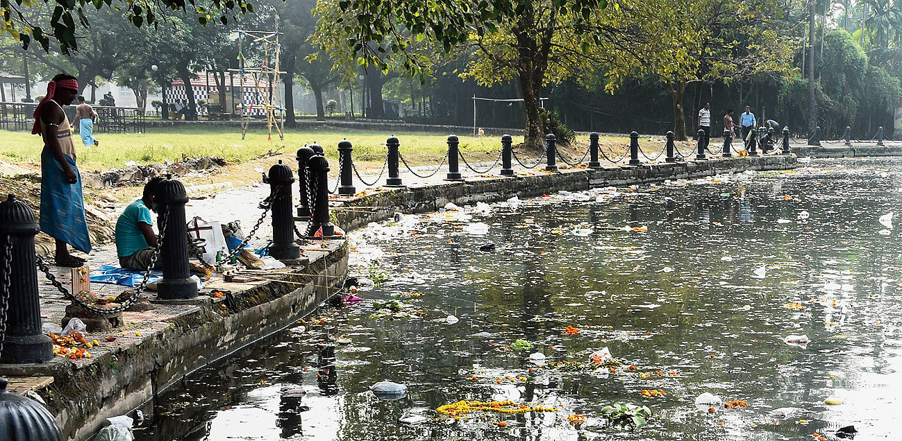 Anglers take position by a dirty waterbody the day after Chhath puja