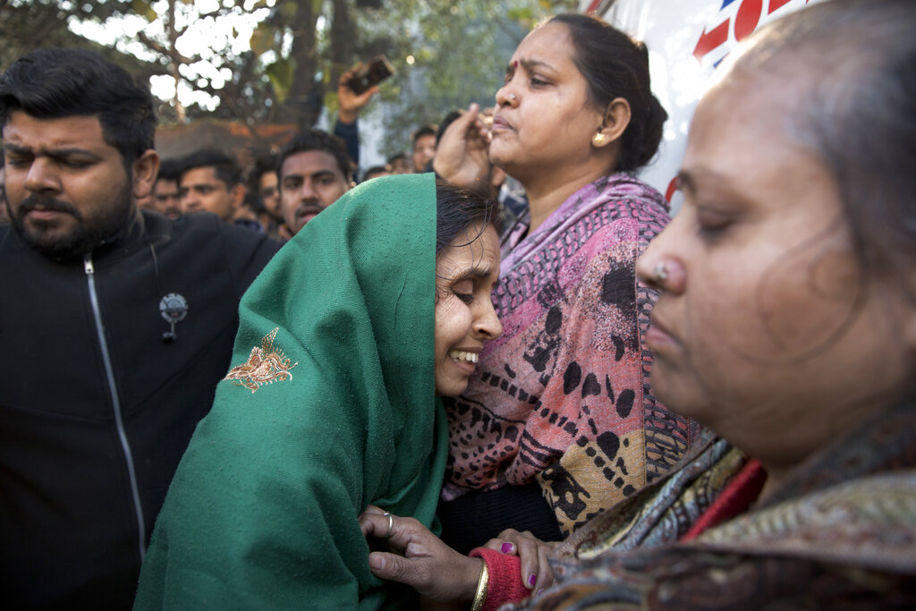 A woman grieves outside Arpit Palace Hotel early on Tuesday morning. 