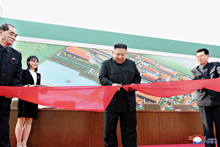 North Korean leader Kim Jong-un cuts a ribbon to inaugurate a fertiliser factory in Sunchon. 
