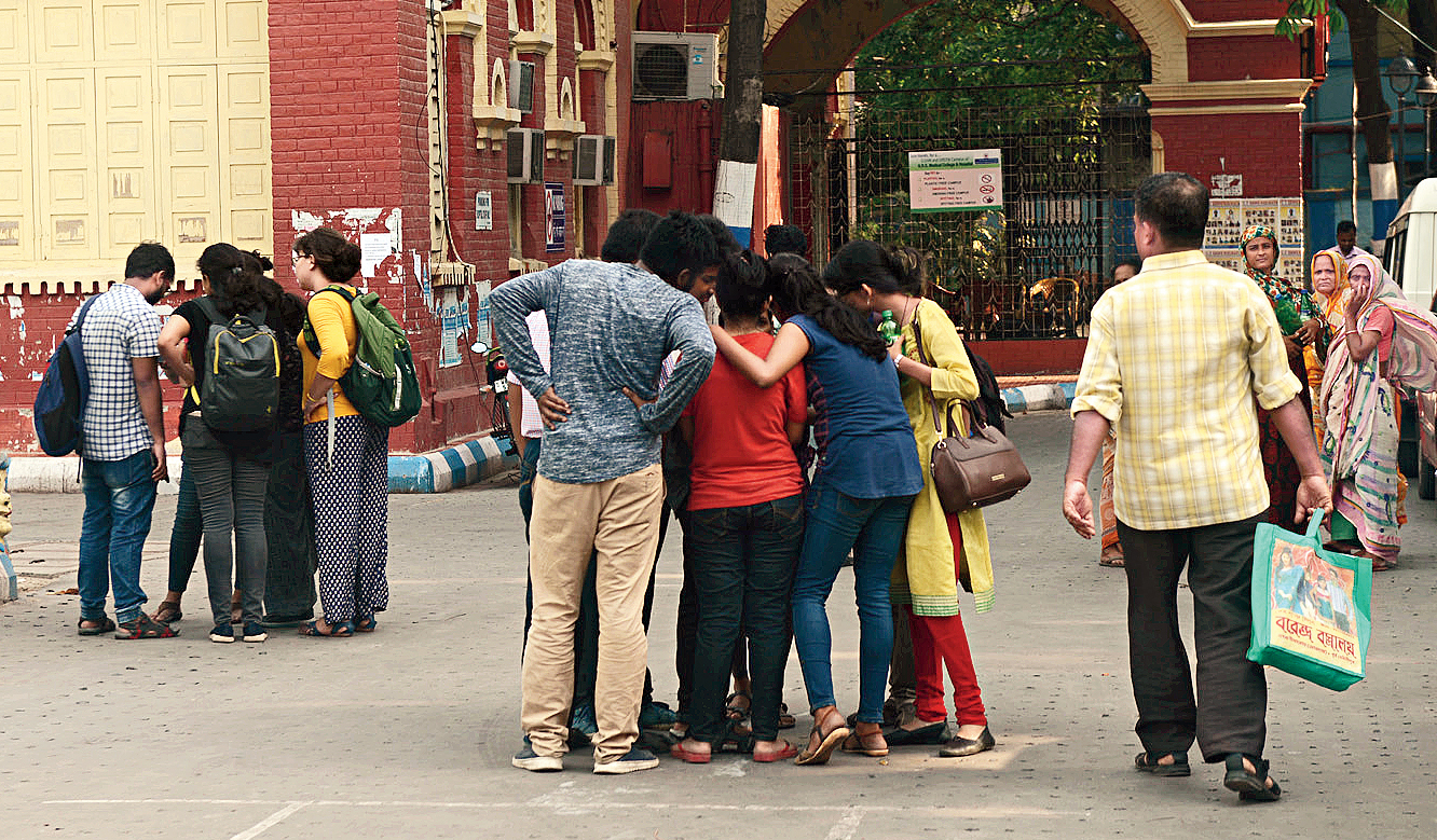 Junior doctors and students huddle in small groups after the general body meeting at NRS hospital on Sunday.