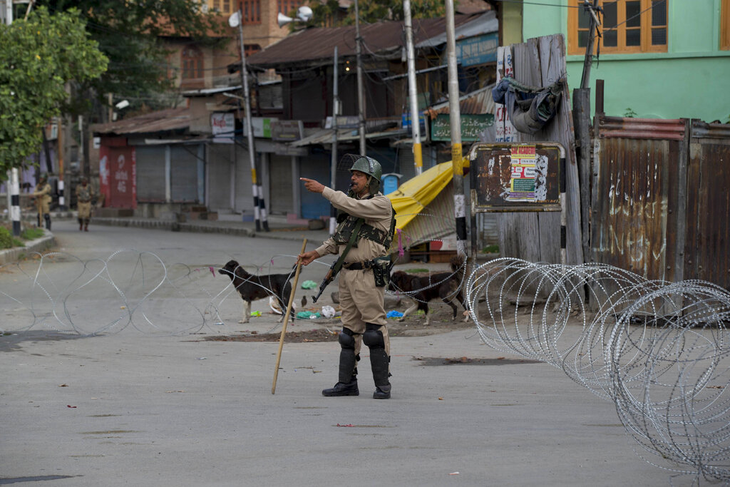 A paramilitary soldier gestures towards a Kashmiri man as he orders him to turn back during lockdown in Srinagar, Kashmir, on Sunday, Aug. 18, 2019 