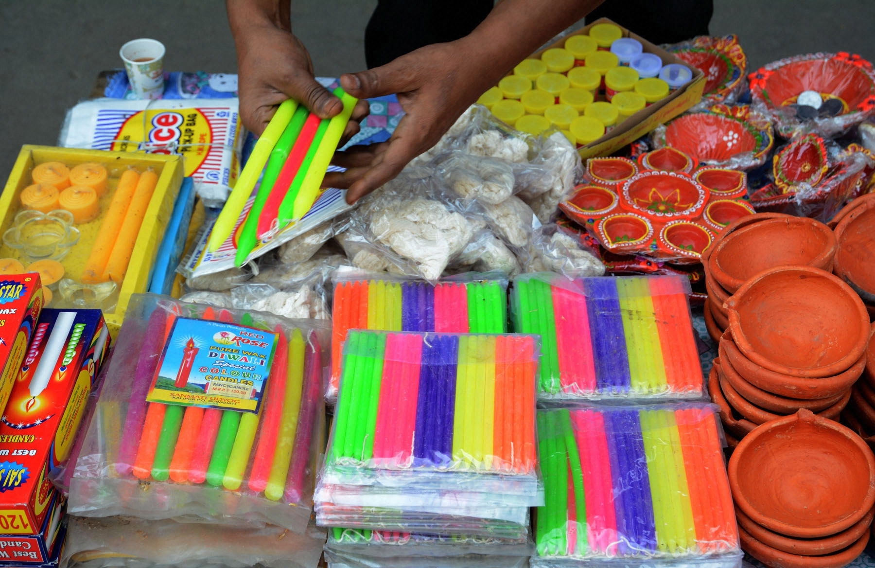 A vendor selling candles and earthen lamps waits for customers during the nationwide lockdown to curb the spread of coronavirus, in Guwahati, Sunday, April 5, 2020. PM Modi had on Friday urged people to switch off the lights at their homes and light up lamps, candles or mobile phone torches for nine minutes at 9pm on April 5 to display the country's collective resolve to defeat coronavirus