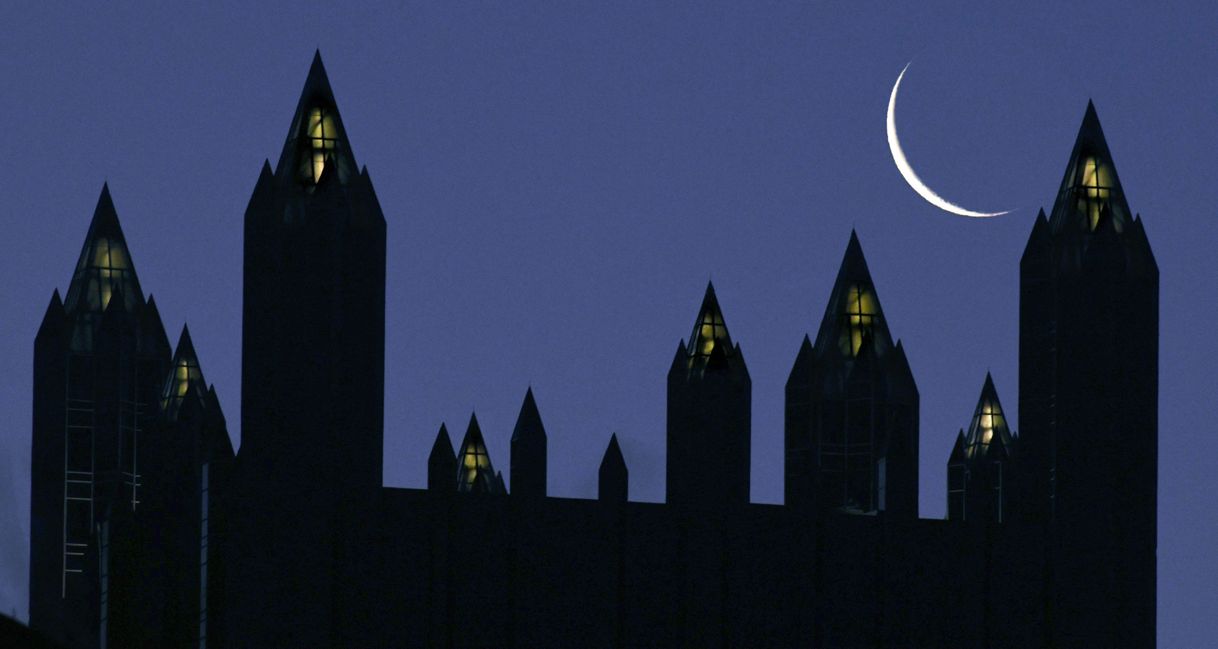 The crescent moon rises over the spires atop of the PPG Place towers, on Wednesday, in downtown Pittsburgh.