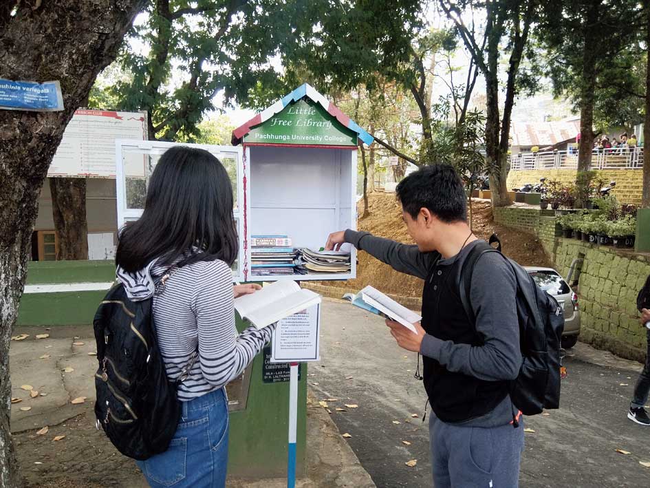 Students browse books at a mini roadside library. 

