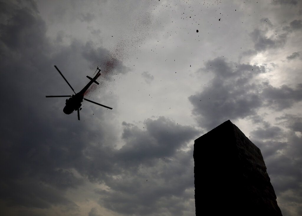 An Indian Air Force helicopter showers flower petals at the National Police Memorial in New Delhi, Sunday, May 3, 2020.