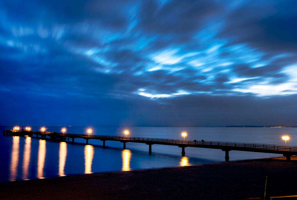 Lamps on the pier shine in Scharbeutz at the Baltic Sea, Germany, early on December 24