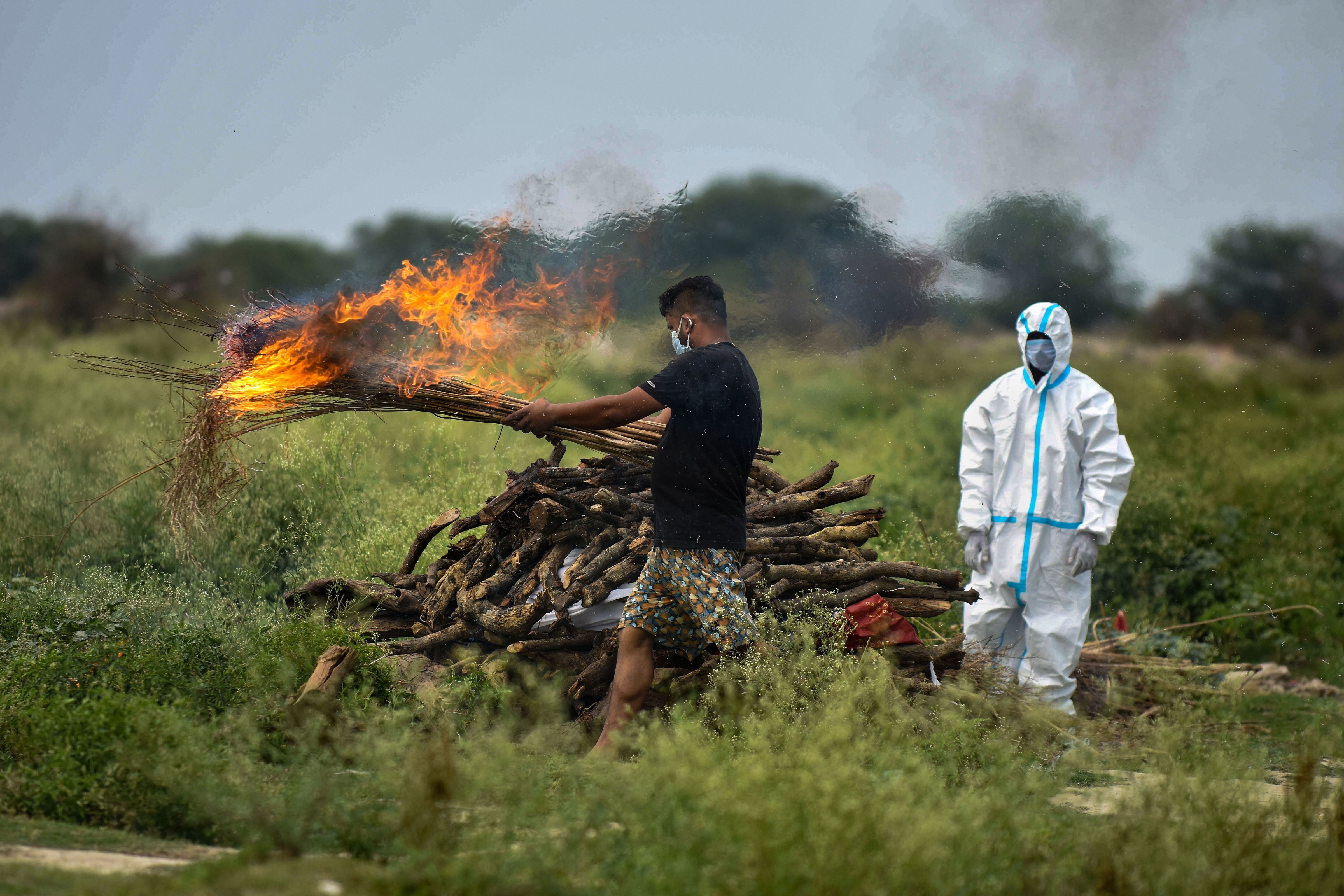 A family member of 47-year-old Virendra Singh, who died of COVID-19, performs his last rites before the cremation during the nationwide lockdown, in Prayagraj, Wednesday, May 6, 2020.