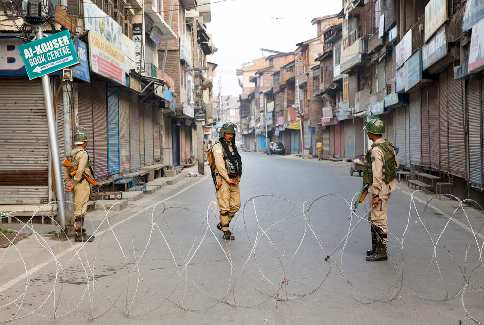 Paramilitary soldiers stand guard near a barbed wire barricade during restrictions in Srinagar on Friday, September 27, 2019.