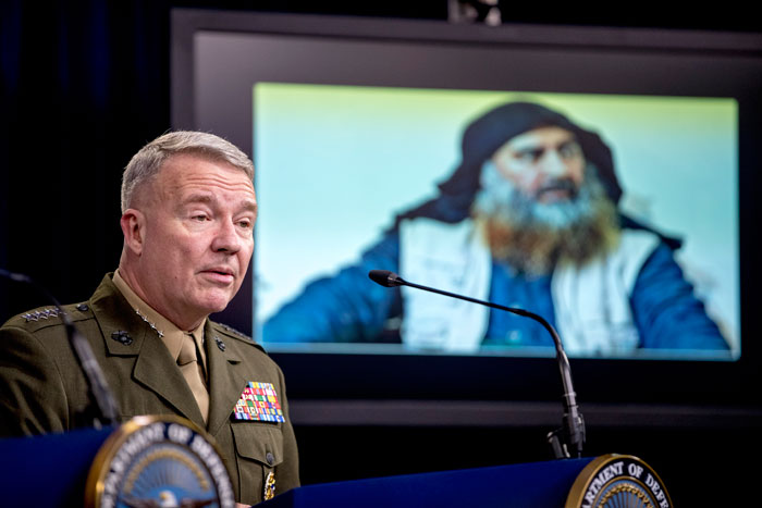 Abu Bakr al-Baghdadi is displayed on a monitor as US Central Command Commander Marine Gen. Kenneth McKenzie speaks at a joint press briefing at the Pentagon in Washington on the al-Baghdadi raid
