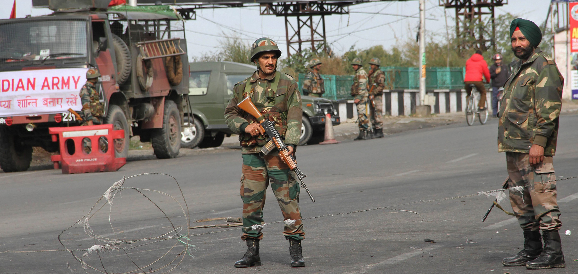 Army personnel stand guard at a road during the fourth consecutive day of the curfew in Jammu on Monday, February 18.