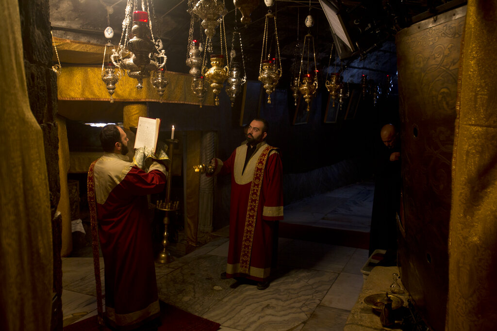 Christian Armenian pray inside the Grotto of the Church of the Nativity, traditionally believed by Christians to be the birthplace of Jesus Christ, in the West Bank city of Bethlehem on Christmas Eve, Tuesday, Dec. 24, 2019.