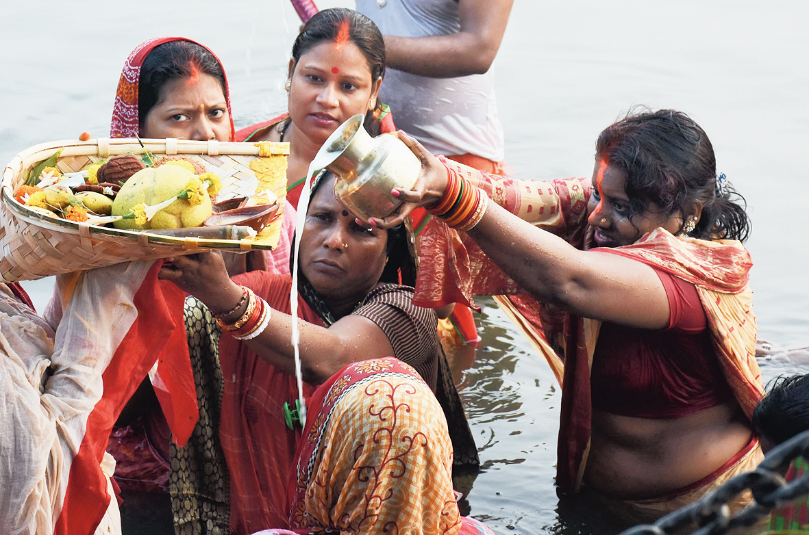 Women pour milk into the waterbody as part of the ritual