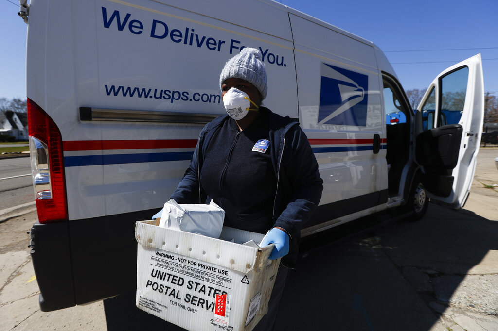  United States Postal worker makes a delivery with gloves and a mask in Warren, Michigan on Thursday, April 2