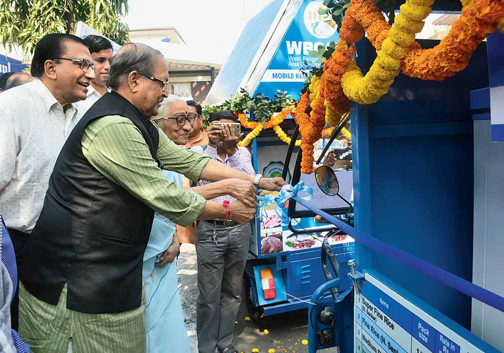 Minister Subrata Mukherjee cuts the ribbon to inaugurate the vans outside CA Market