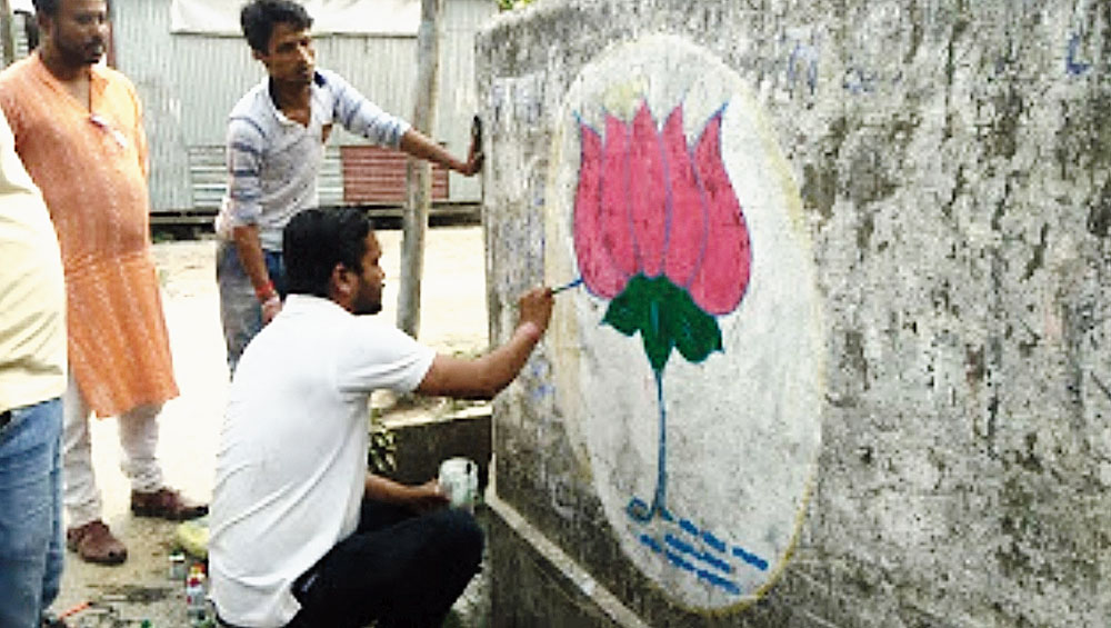 A BJP supporter paints graffiti in Cooch Behar. 