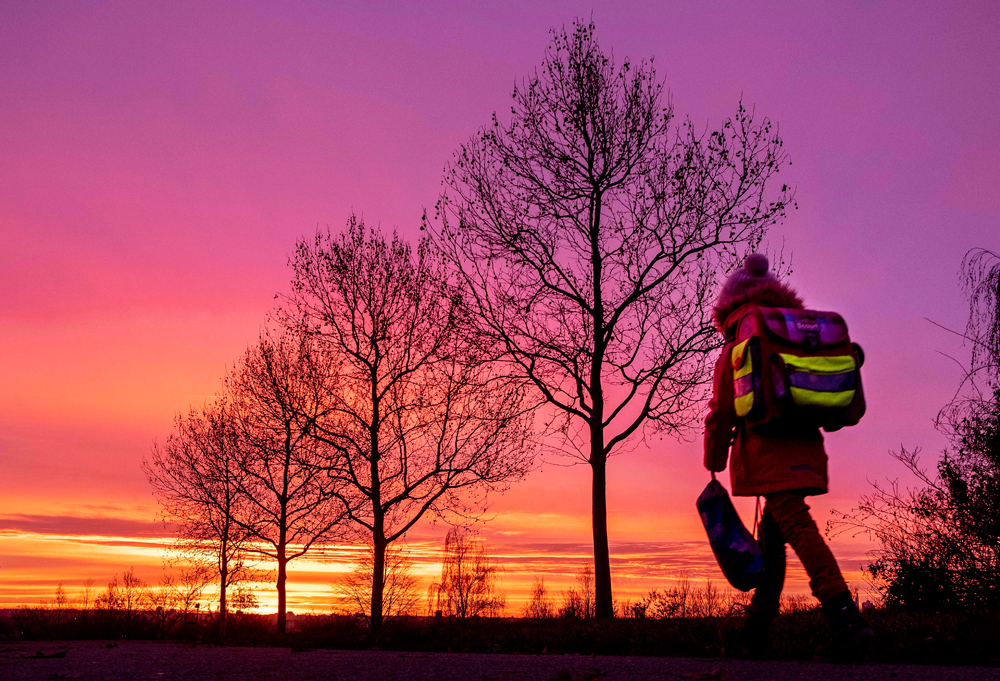A girl goes to school just before sunrise in Frankfurt on December 11