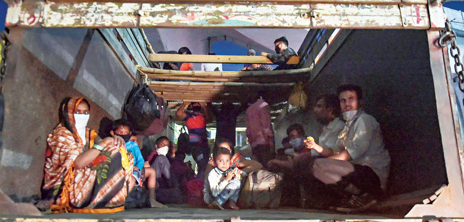 Migrants on a truck in Thane on Monday.