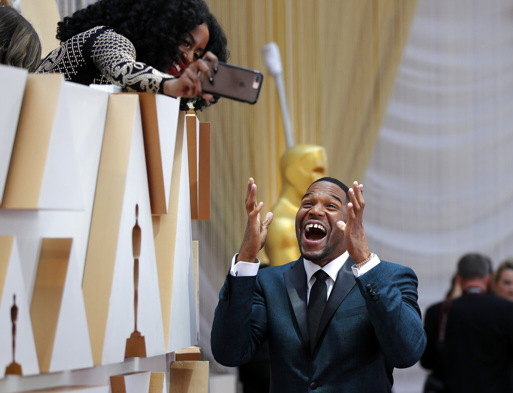 Michael Strahan takes a selfie with a guest as he arrives at the Oscars on Sunday, February 9, 2020, at the Dolby Theatre in Los Angeles