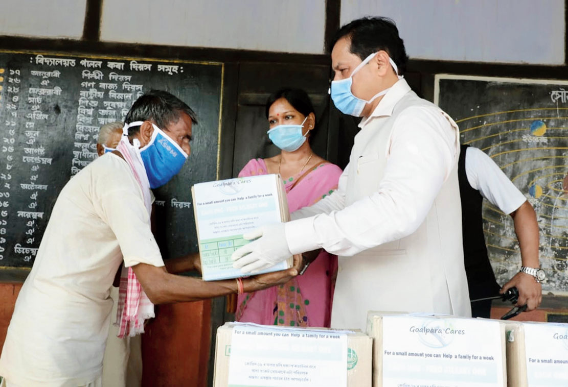 Assam chief minister Sarbananda Sonowal distributes relief materials to the flood-affected at a relief camp in Goalpara on Friday. 
