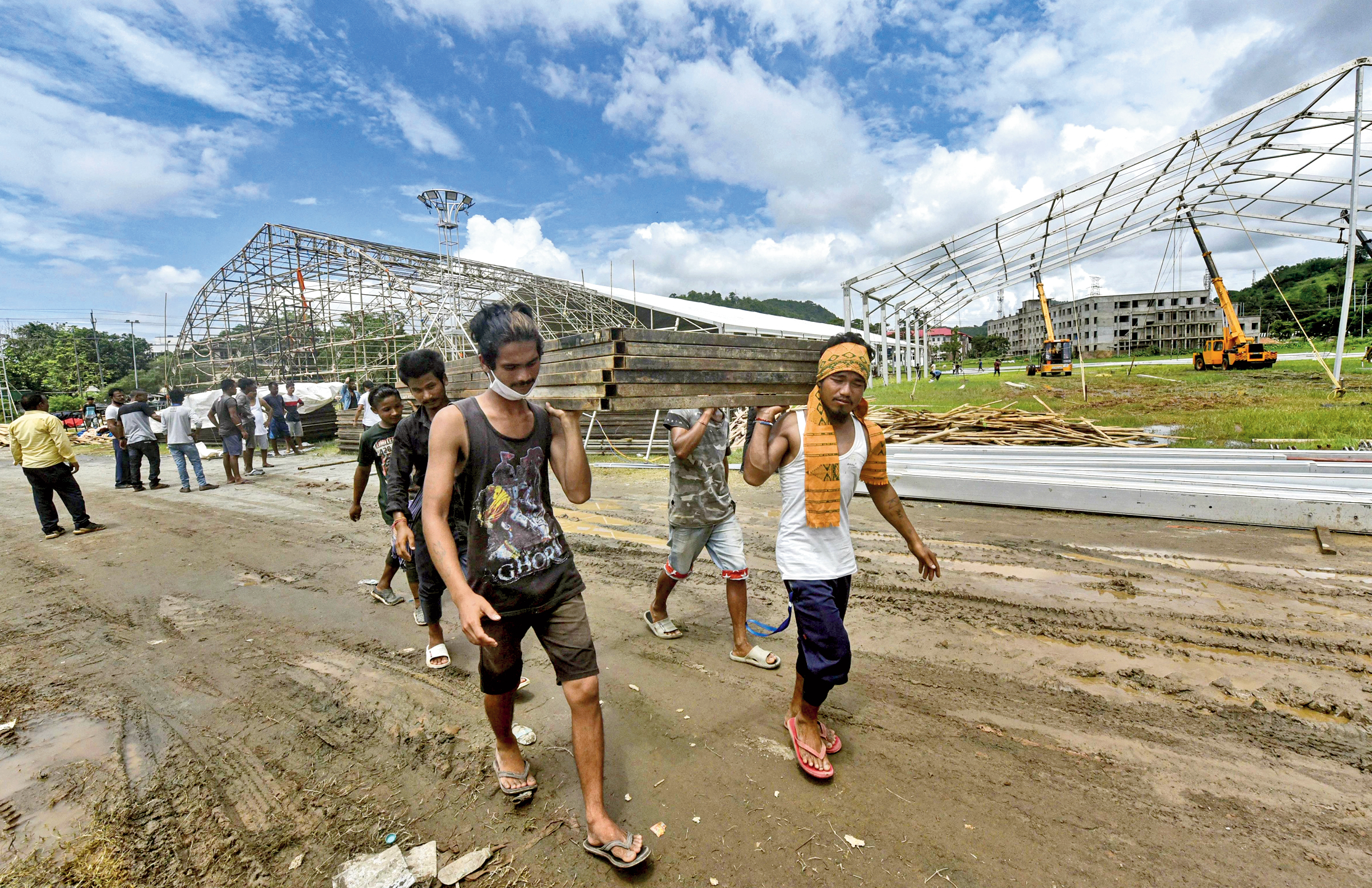 Workers carry material to build a quarantine centre at a veterinary college in Khanapara area of Guwahati on Friday.