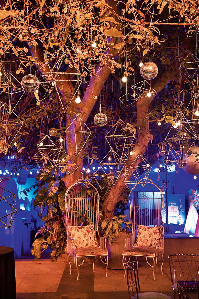 The VIP lounge was divided into two sections — one focussing on a metallic vibe and the other done in neon hues. Around 130 geometric structures were made of cane and wrapped in metallic paper and these were complemented by 50 disco balls and 150 bulbs to create that warm ambient mood. This zone also had lots of mix-and-match furniture and tables by Inspire Decor & Rentals that made all the adda session relaxed and fun!