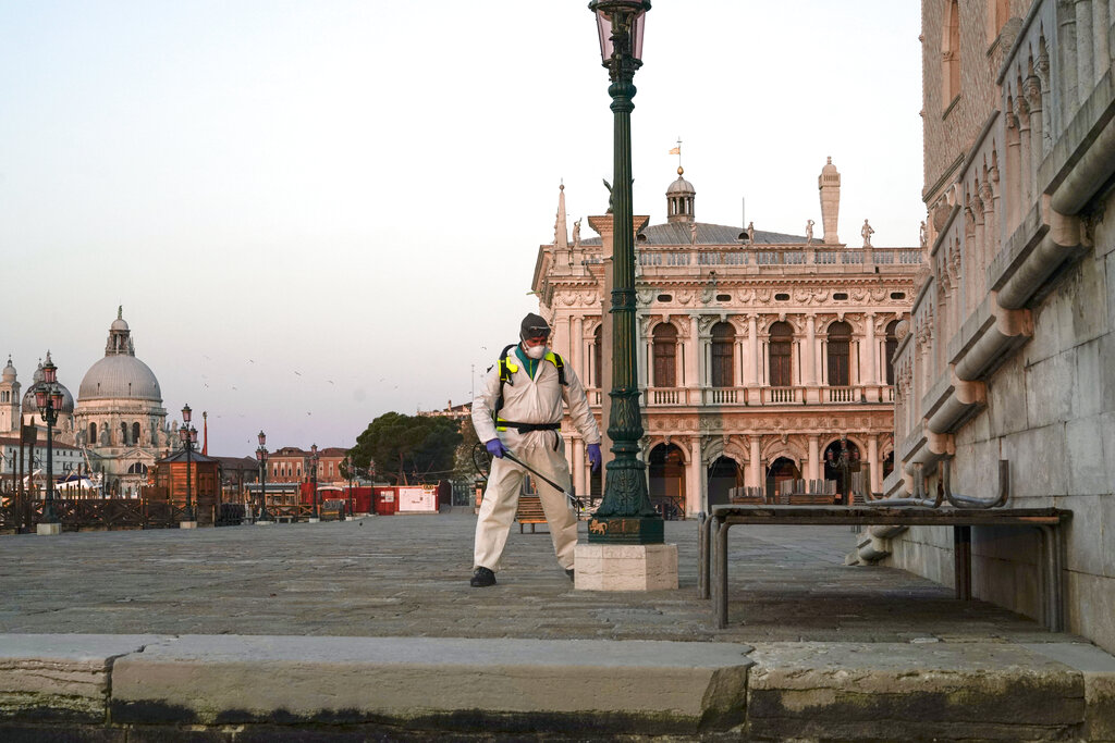 A worker sanitizes streets near San Marco, in Venice, on Monday. The government is demanding Italians stay home and not take the leveling off of new coronavirus infections as a sign the emergency is over, following evidence that more and more Italians are relaxing restrictions the west's first and most extreme nationwide lockdown and production shutdown.